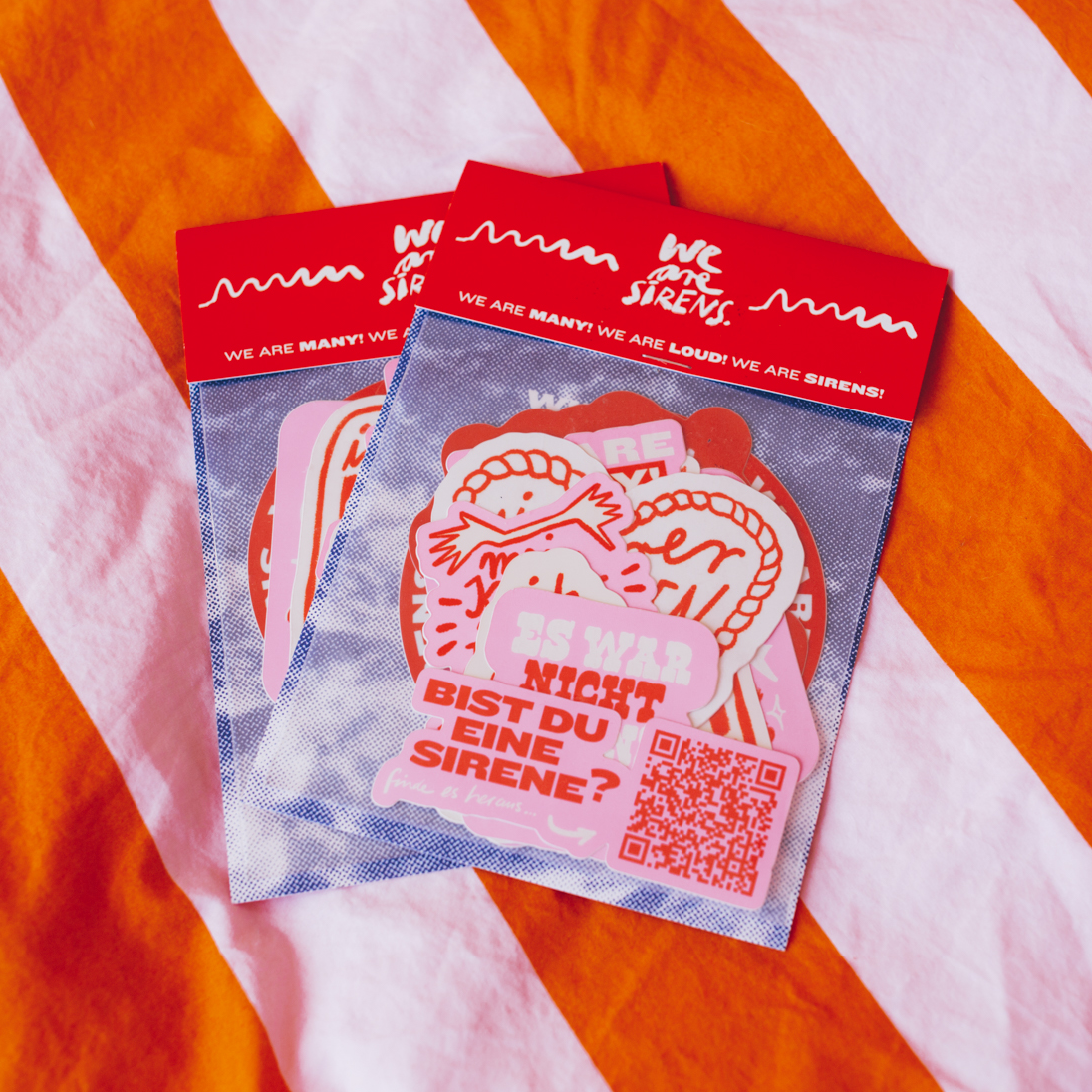 Two packs of colorful sticker sheets with German text, featuring bold designs and a QR code.