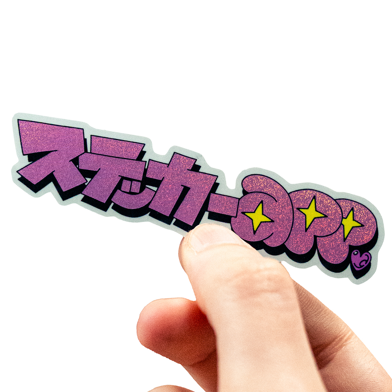 Hand holding a Pixie Dust sticker with Japanese text with 15 percent white layer, against a white background