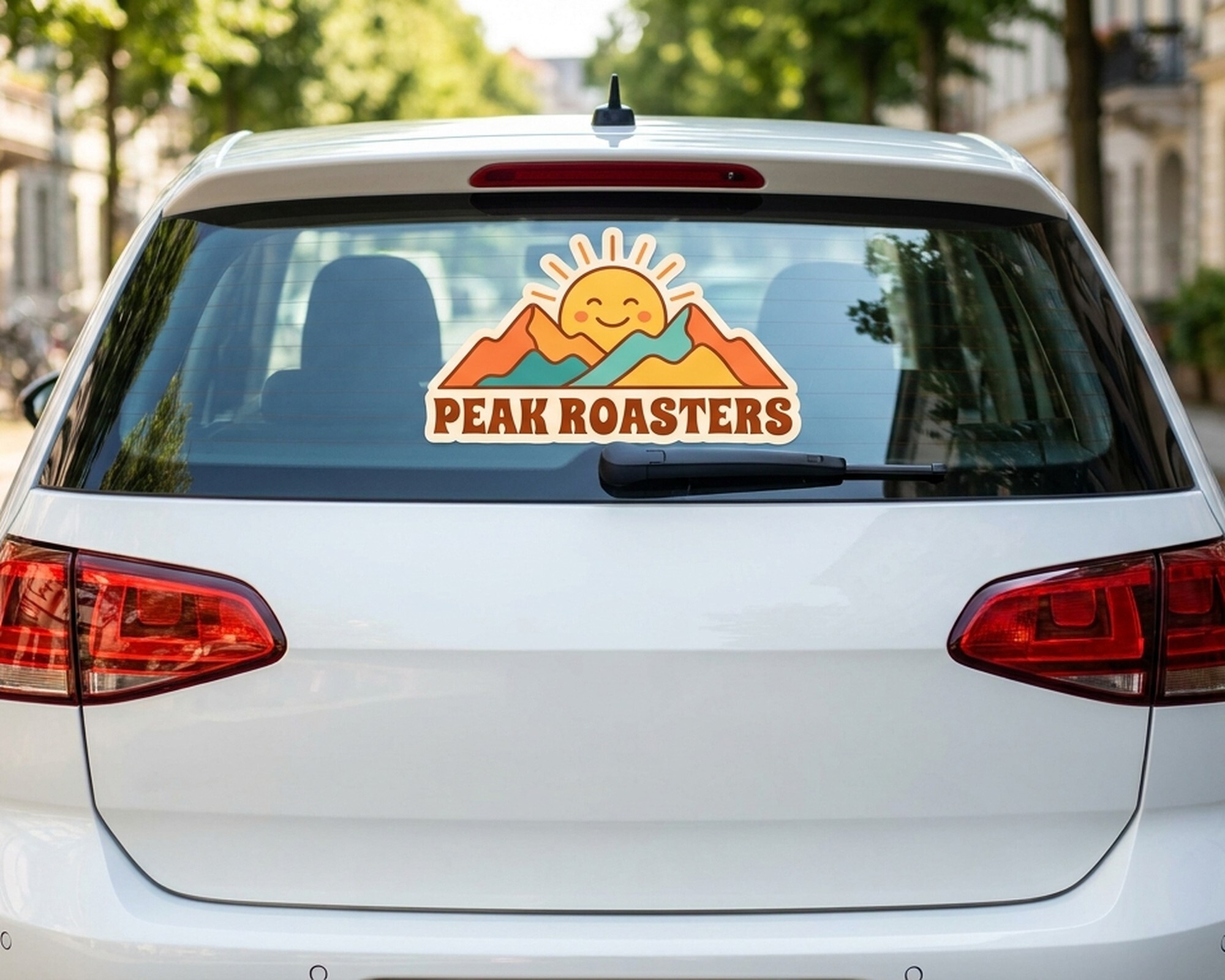 Decalcomania personalizzata fustellata con logo di sole e montagne e la scritta "Peak Roasters" sul lunotto di un'auto